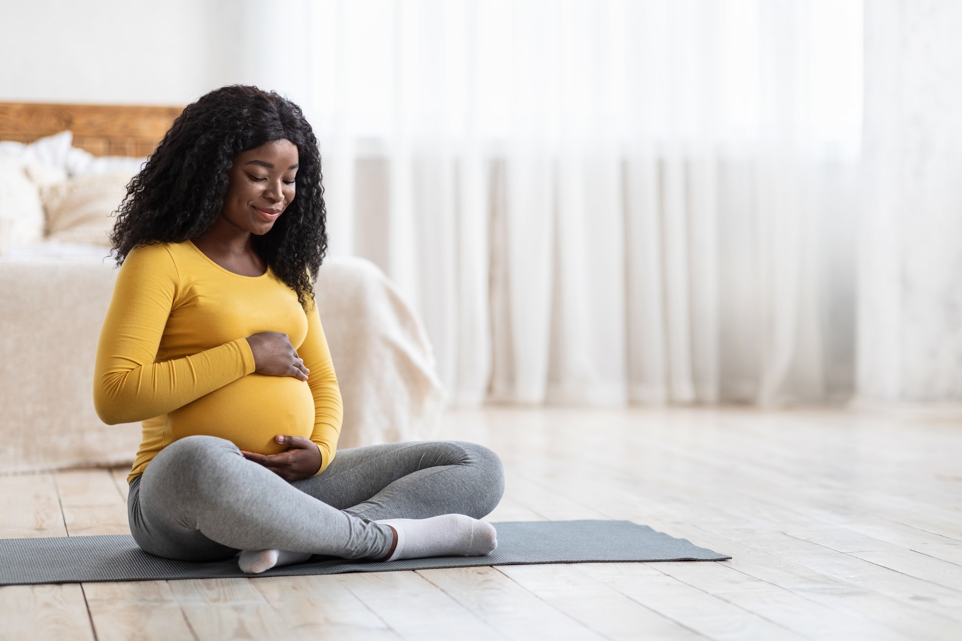 Pregnant african woman doing sport at home